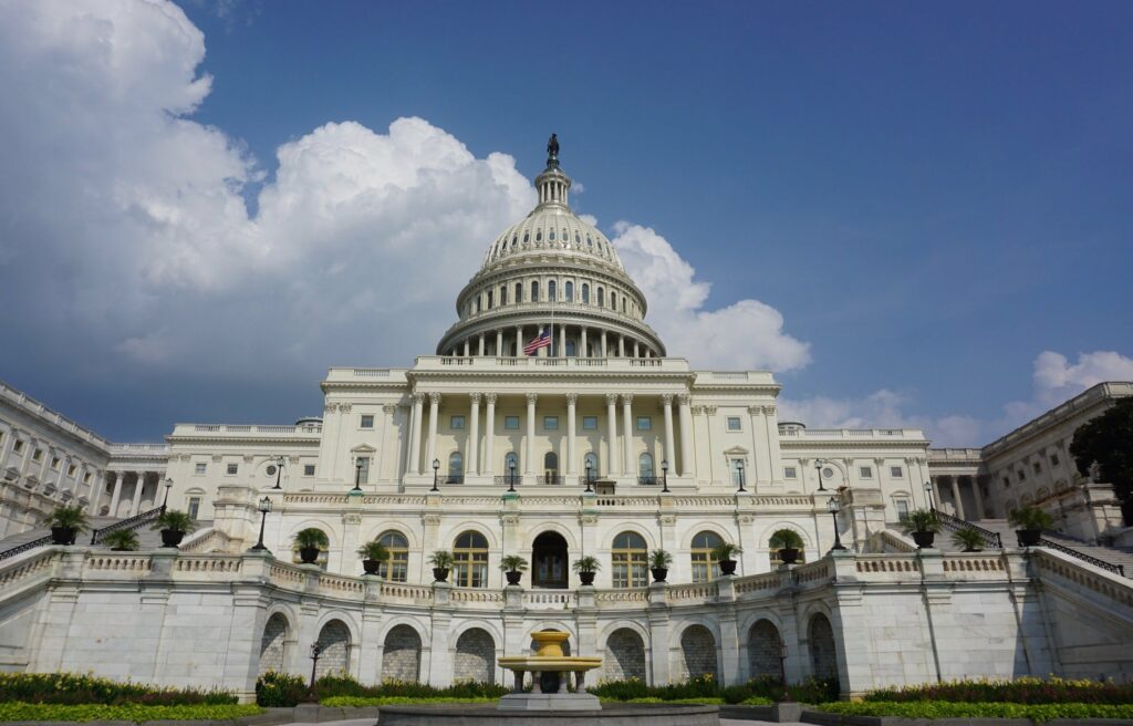 Front facing photo of the U.S. Capitol building under a partially cloudy sky